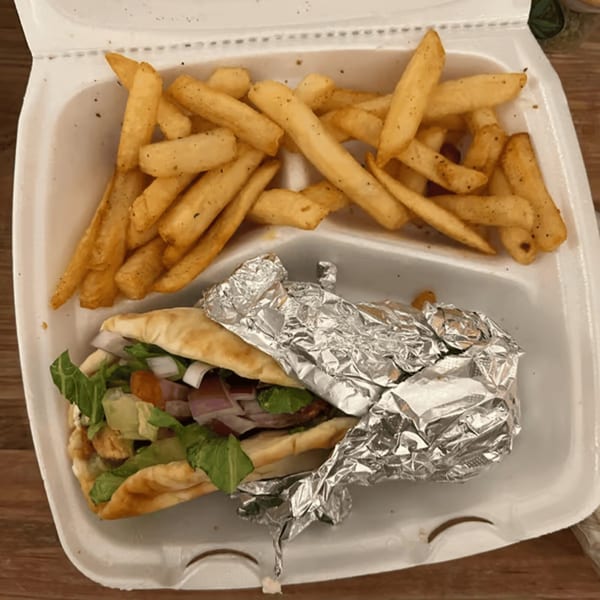 Blue Olive Grill's Mediterranean pita sandwich with lettuce, onions, and avocado, served with french fries.