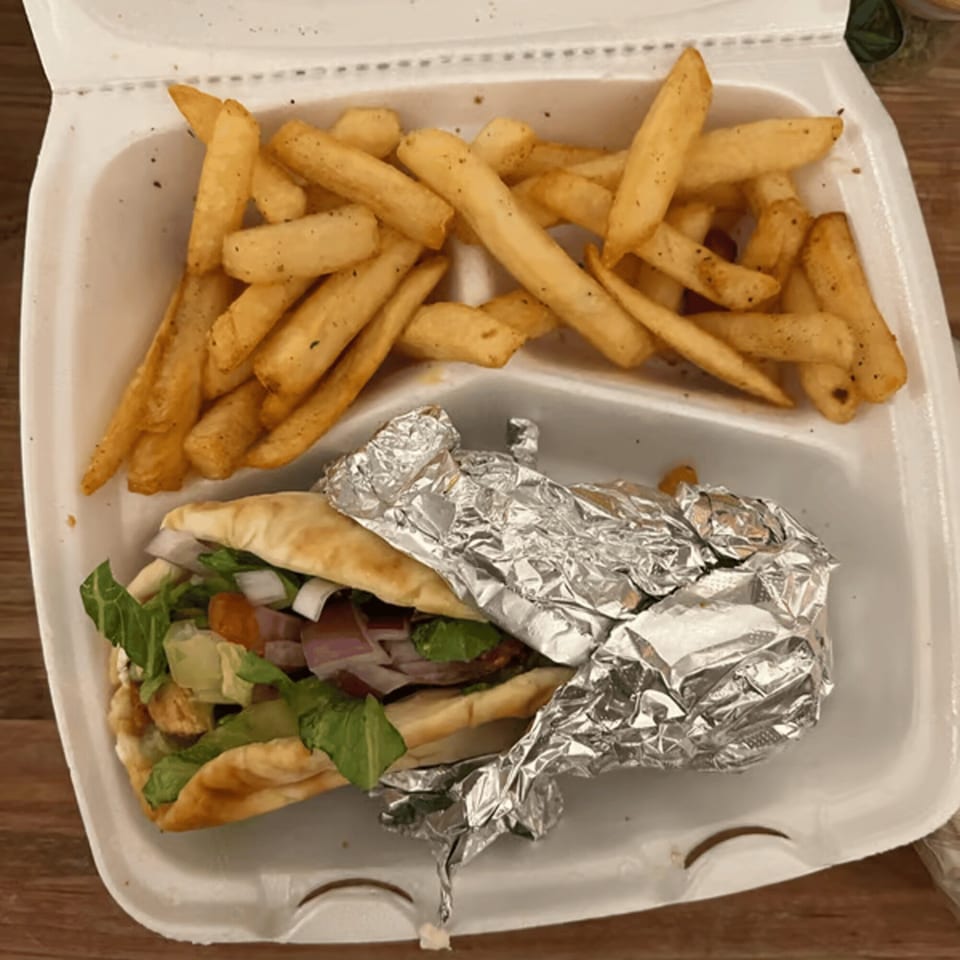 Blue Olive Grill's Mediterranean pita sandwich with lettuce, onions, and avocado, served with french fries.