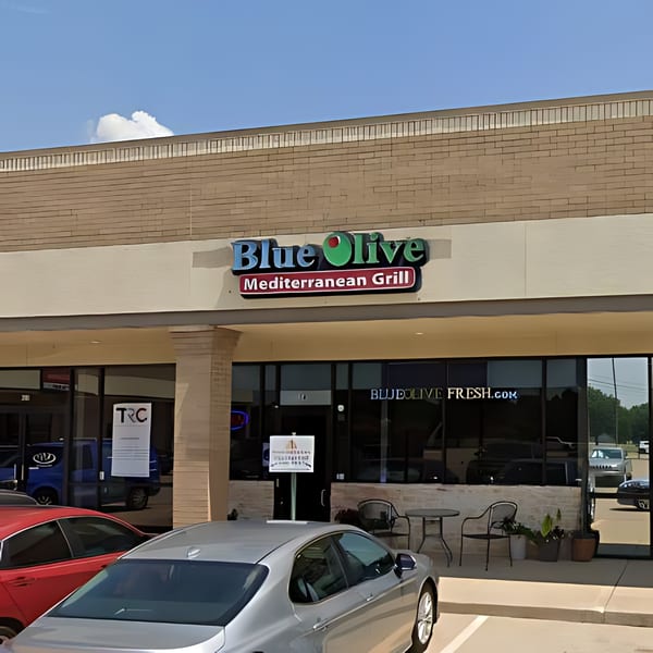 Exterior of Blue Olive Mediterranean Grill with its sign, storefront, and outdoor seating.